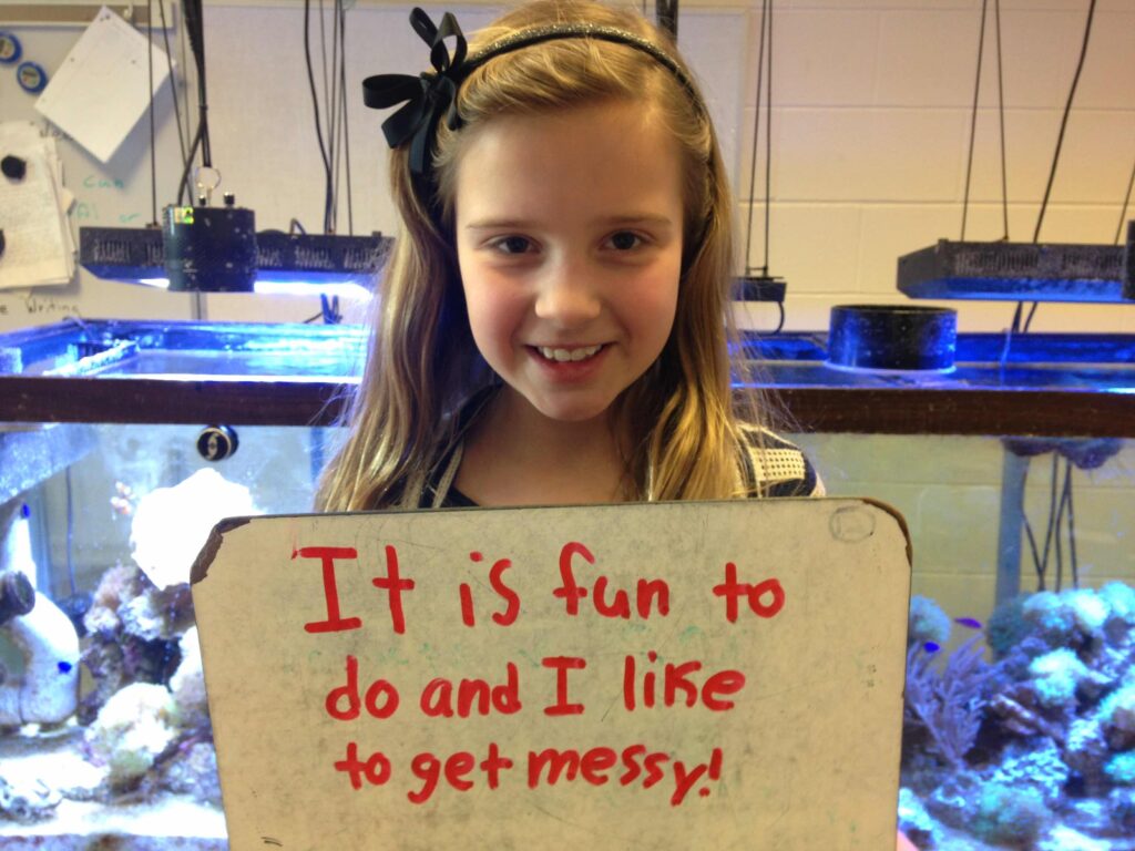 A student from Robeson Elementary visits the coral reef project on Saturday and is asked to define science.