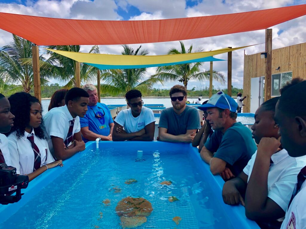 Students and others gather around a coral raceway with Coral Vita co-founder Gator Halpern (center right) in late May, 2019.