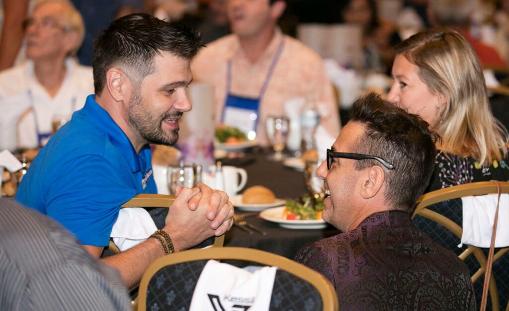 Jake Adams and Rich Ross (right) share a candid moment during the banquet at the 2018 MACNA in Las Vegas. Image courtesy MASNA/Sumer Tiwari.